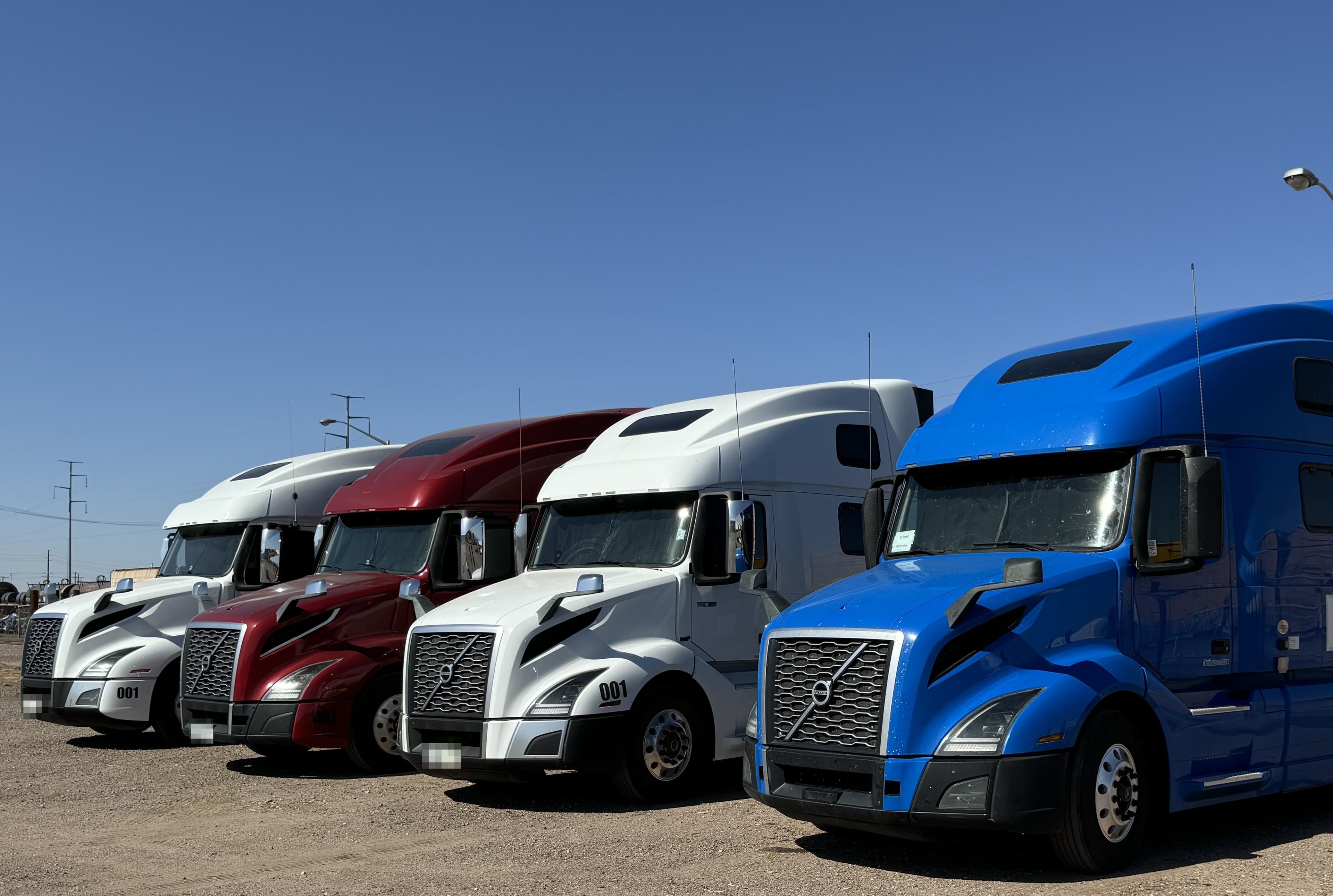 A lineup of semi trucks secured through OTR Consulting trucking business programs