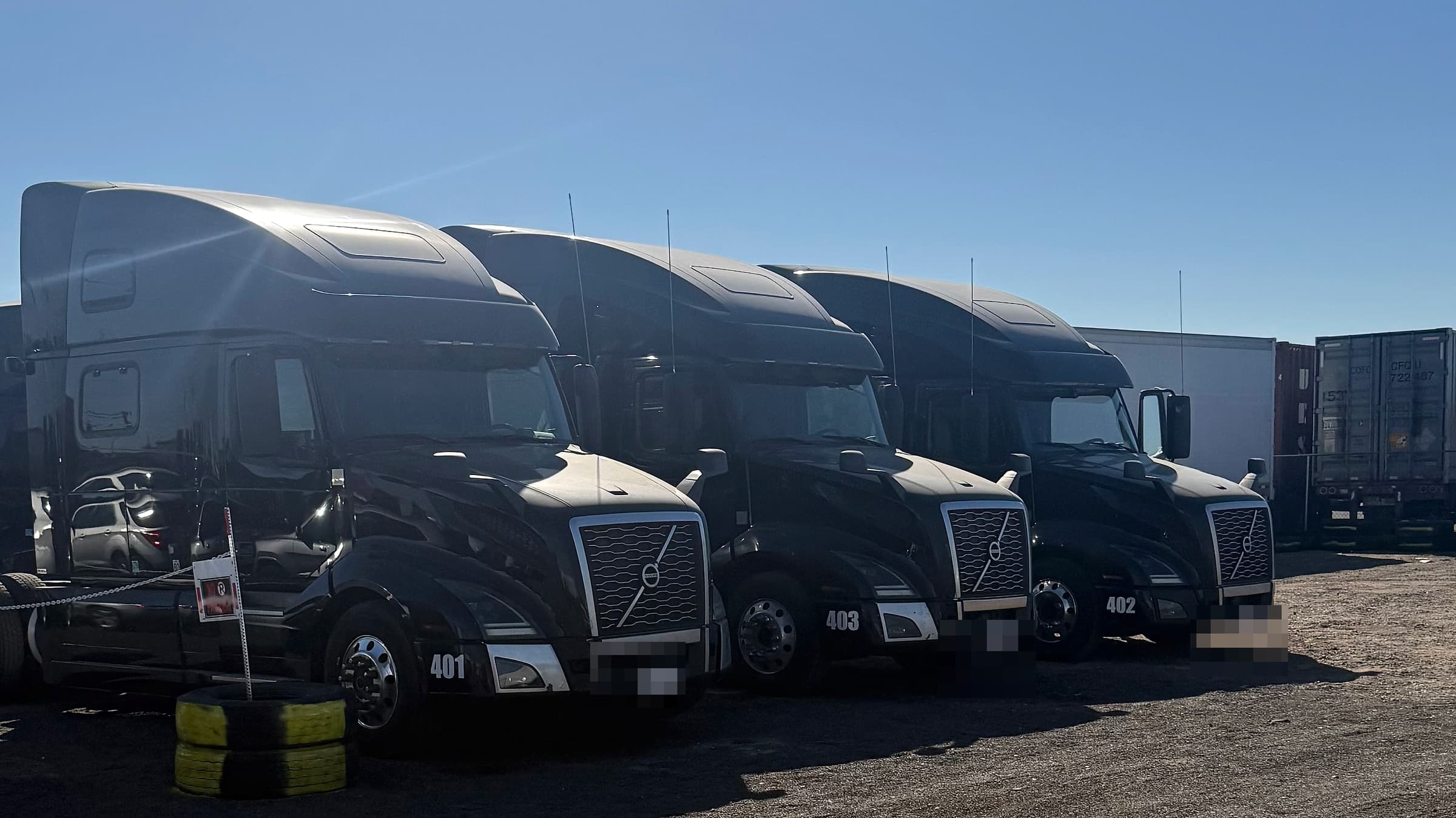 Three black Volvo trucks from a completed OTR Consulting build-out, titled to the client's business after funding